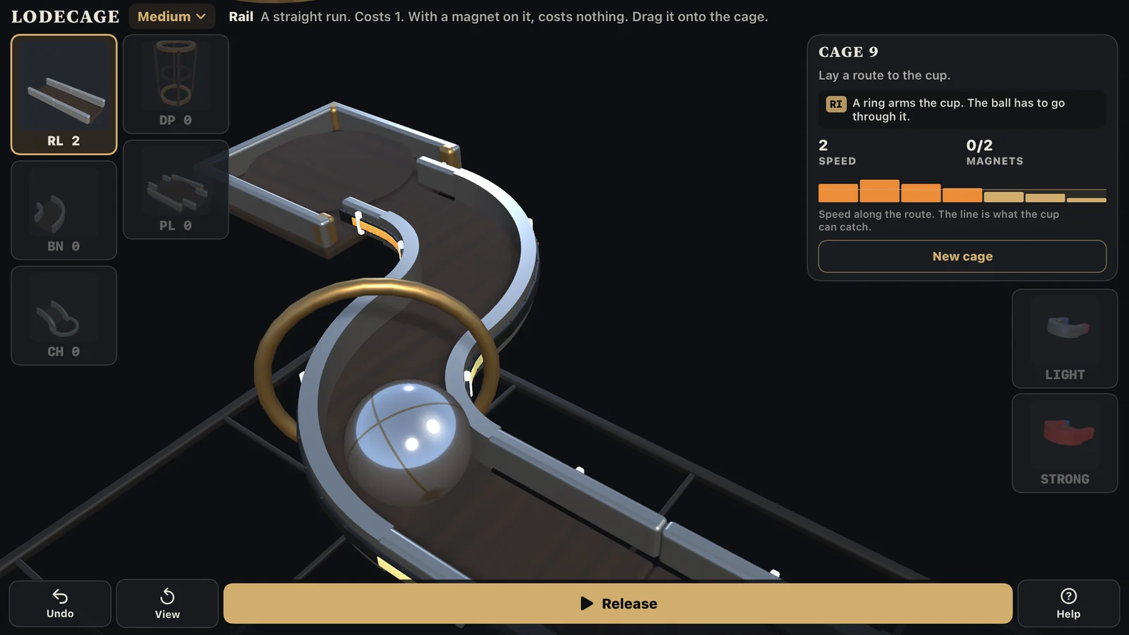 A LodeCage Medium cage: the brass ring stands across the track and the ball is rolling toward it, with the card naming the ring