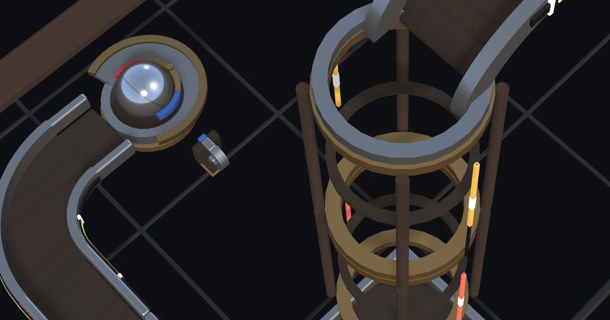 The steel ball held in the LodeCage cup by the catcher magnet at the end of a bend, with a pole magnet bolted beside the cup and a drop tower nearby